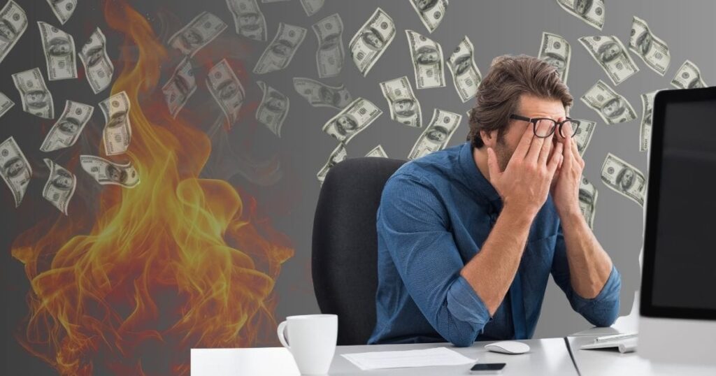 Man sitting in chair burning his money on a bad website